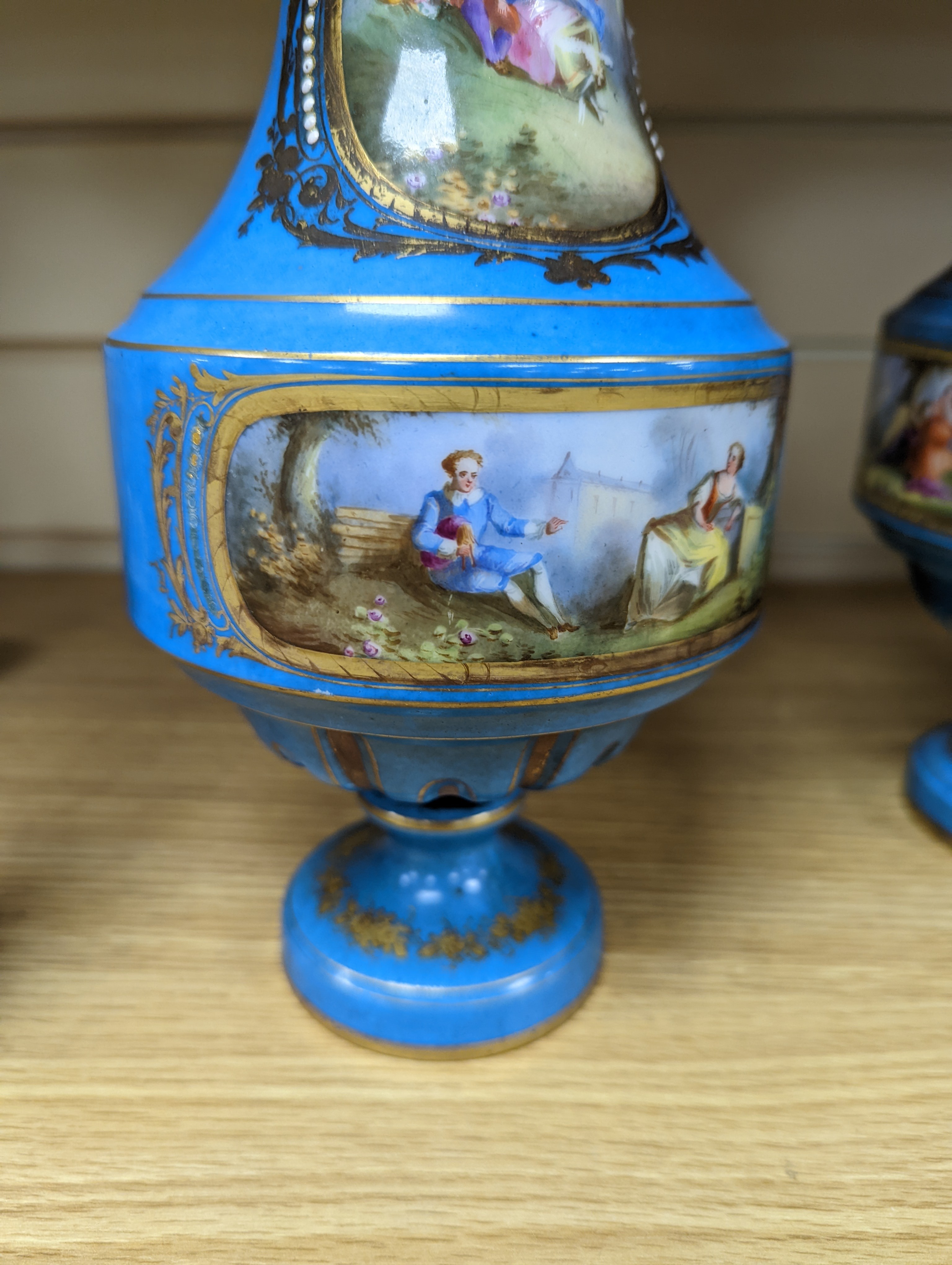 A pair of Sevres style porcelain bleu celeste ground vases and covers, 34cm